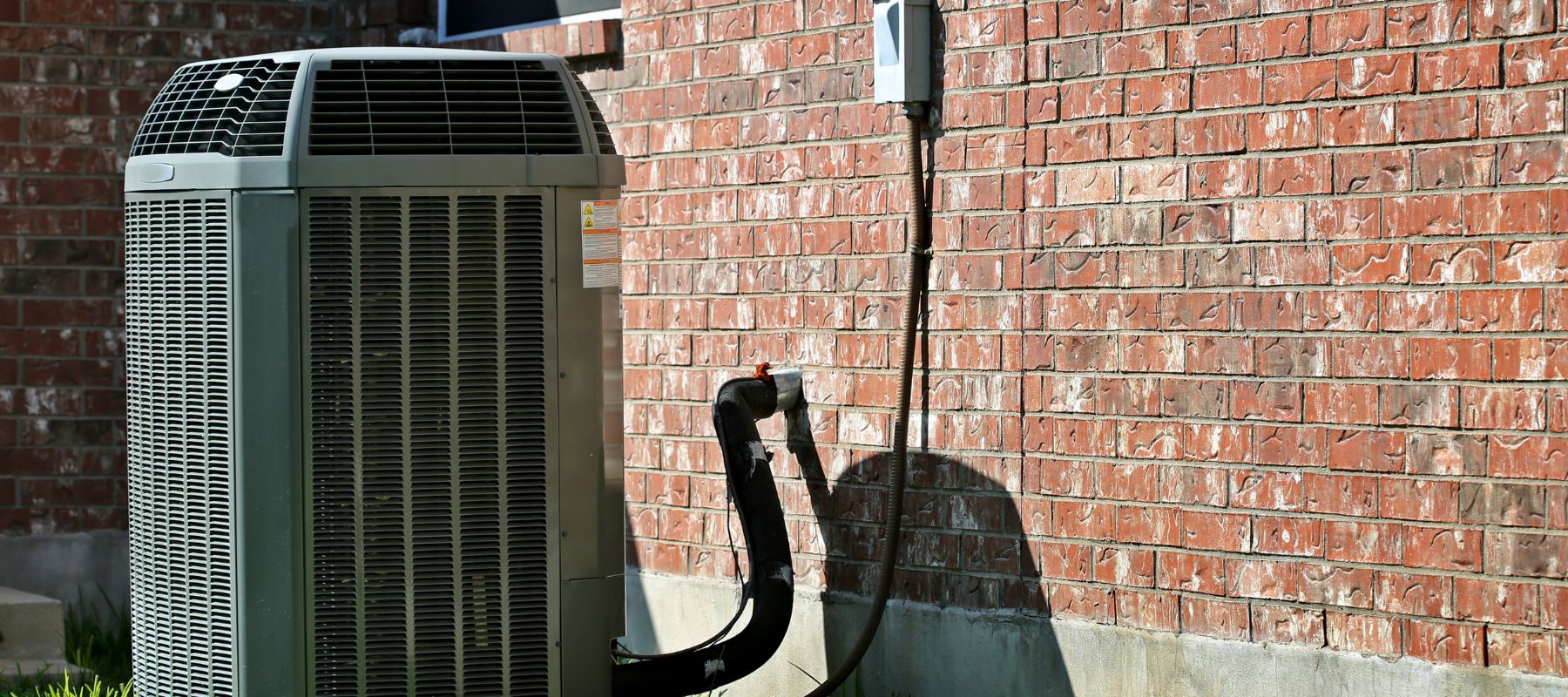 outdoor hvac unit outside of a brick house